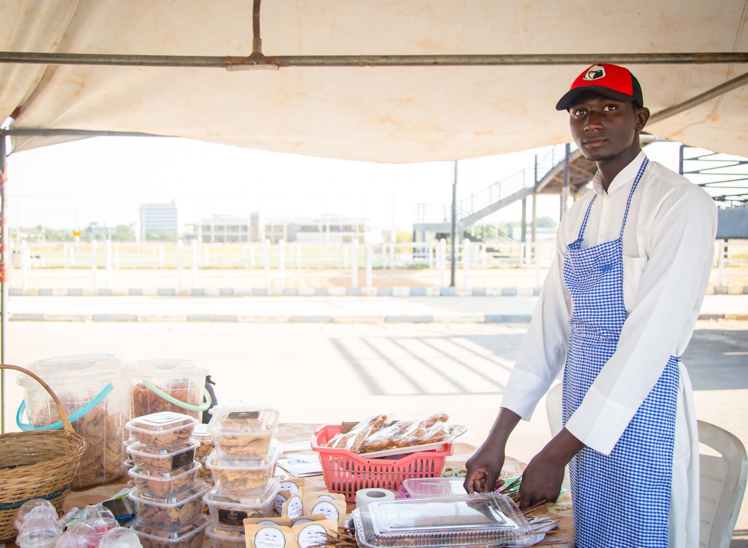 Entrepreneur at a market stall speaking to customers